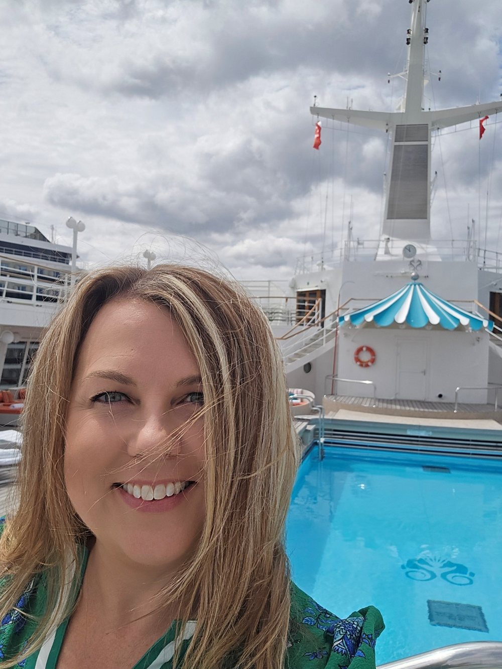 Amy Kilbreath smiling on the pool deck of a cruise ship